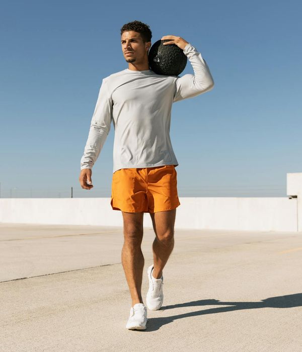Man performing a controlled strength exercise in a modern gym.