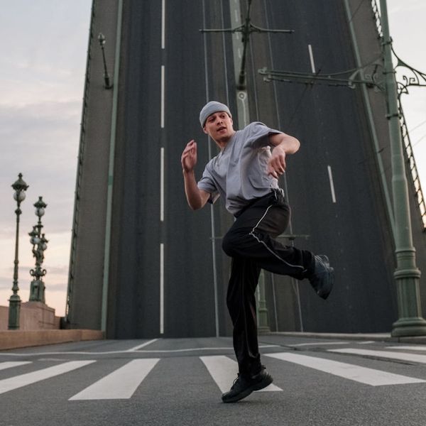 Silhouette of a man stretching against a bright, energetic background.